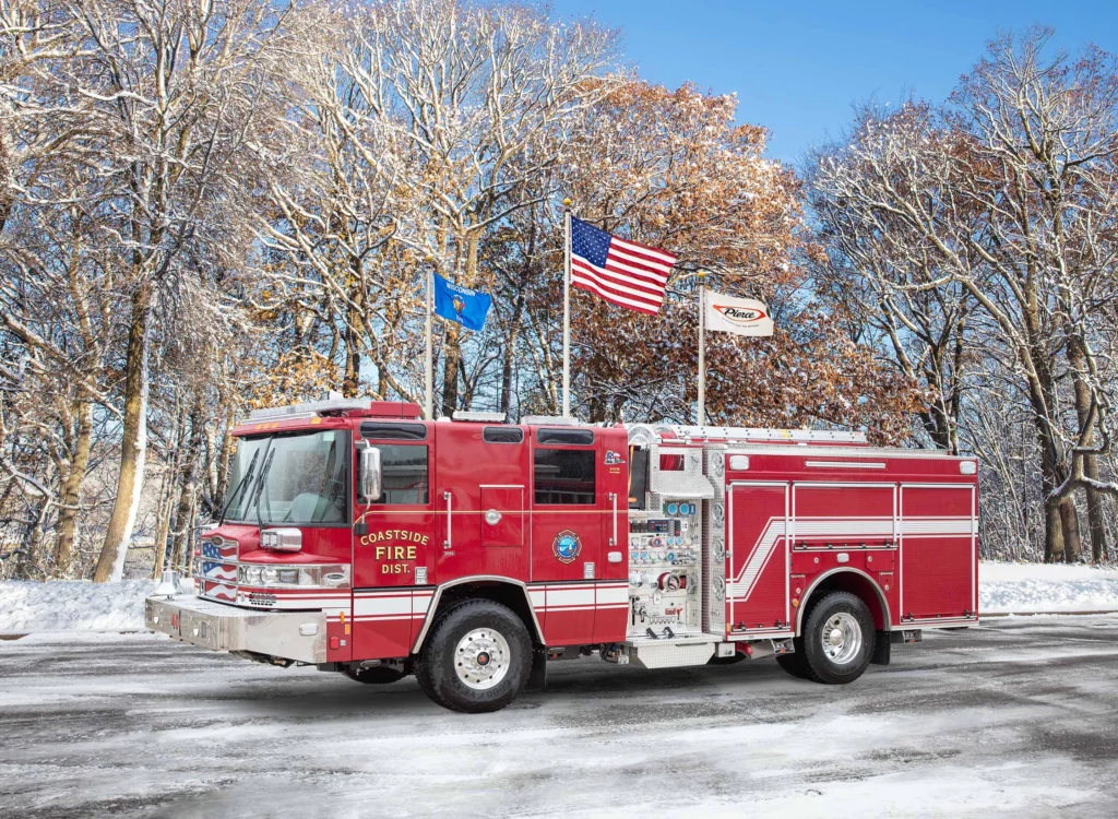 a fire truck in front of flag poles with snow on the ground