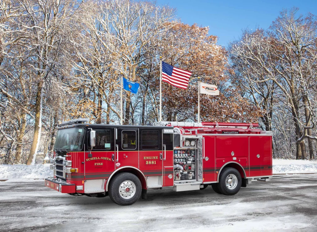fire truck in front of flag poles with snow on the ground